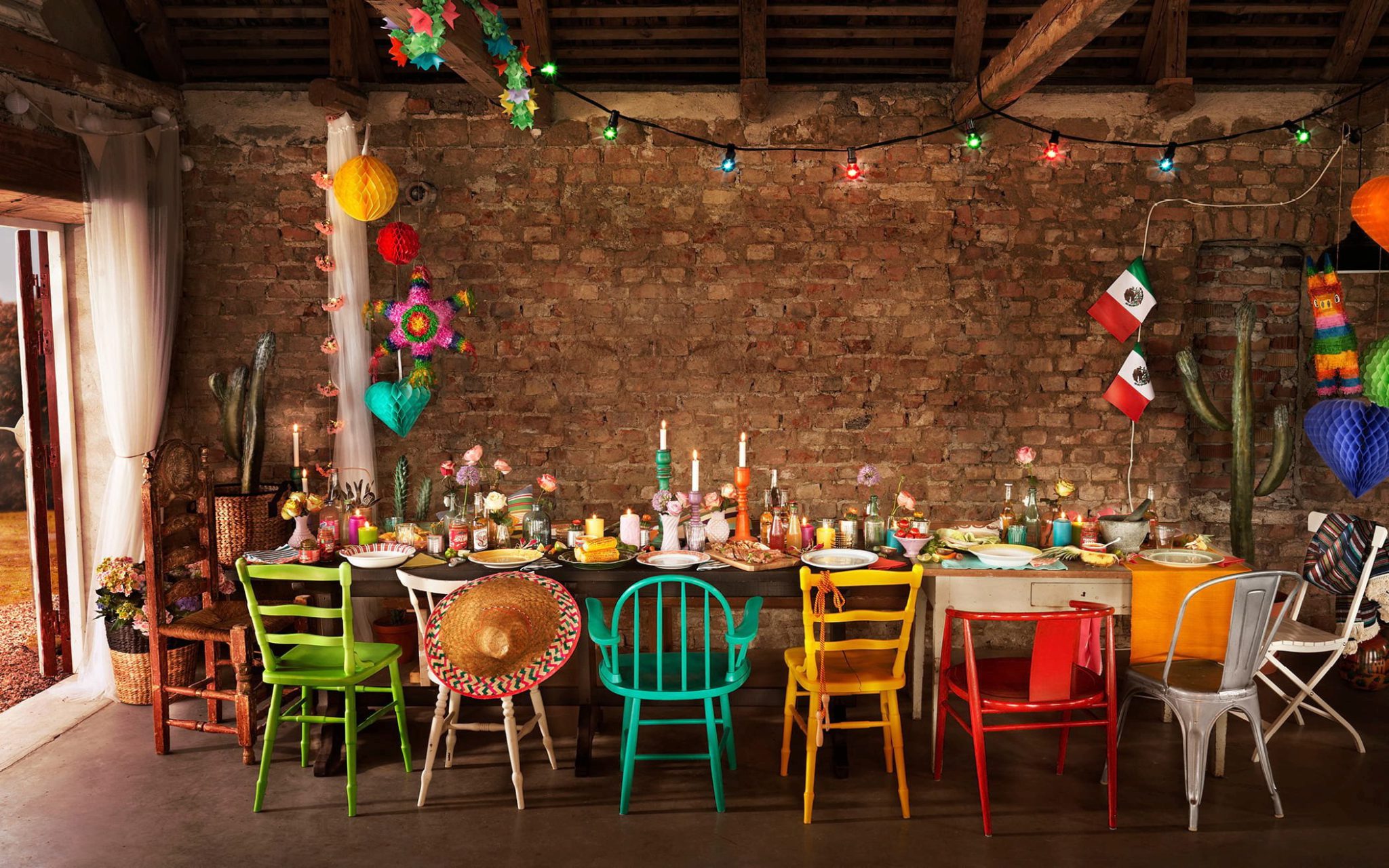Långbord dukat med mexikanskt tema och färgglada stolar runt bordet