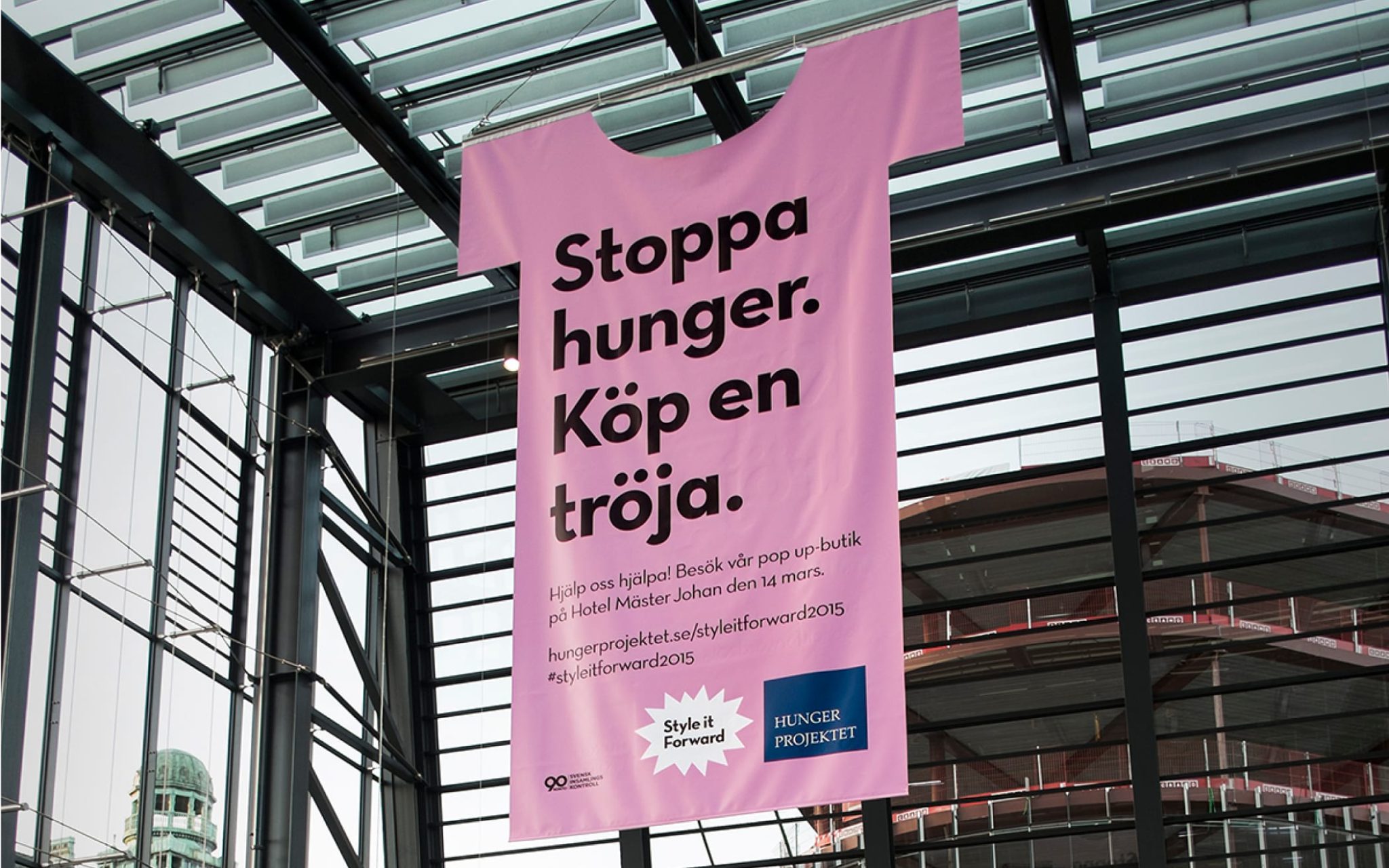 Hängande reklam i form av en tröja i rosa för hungerprojektet inne på Centralen Malmö