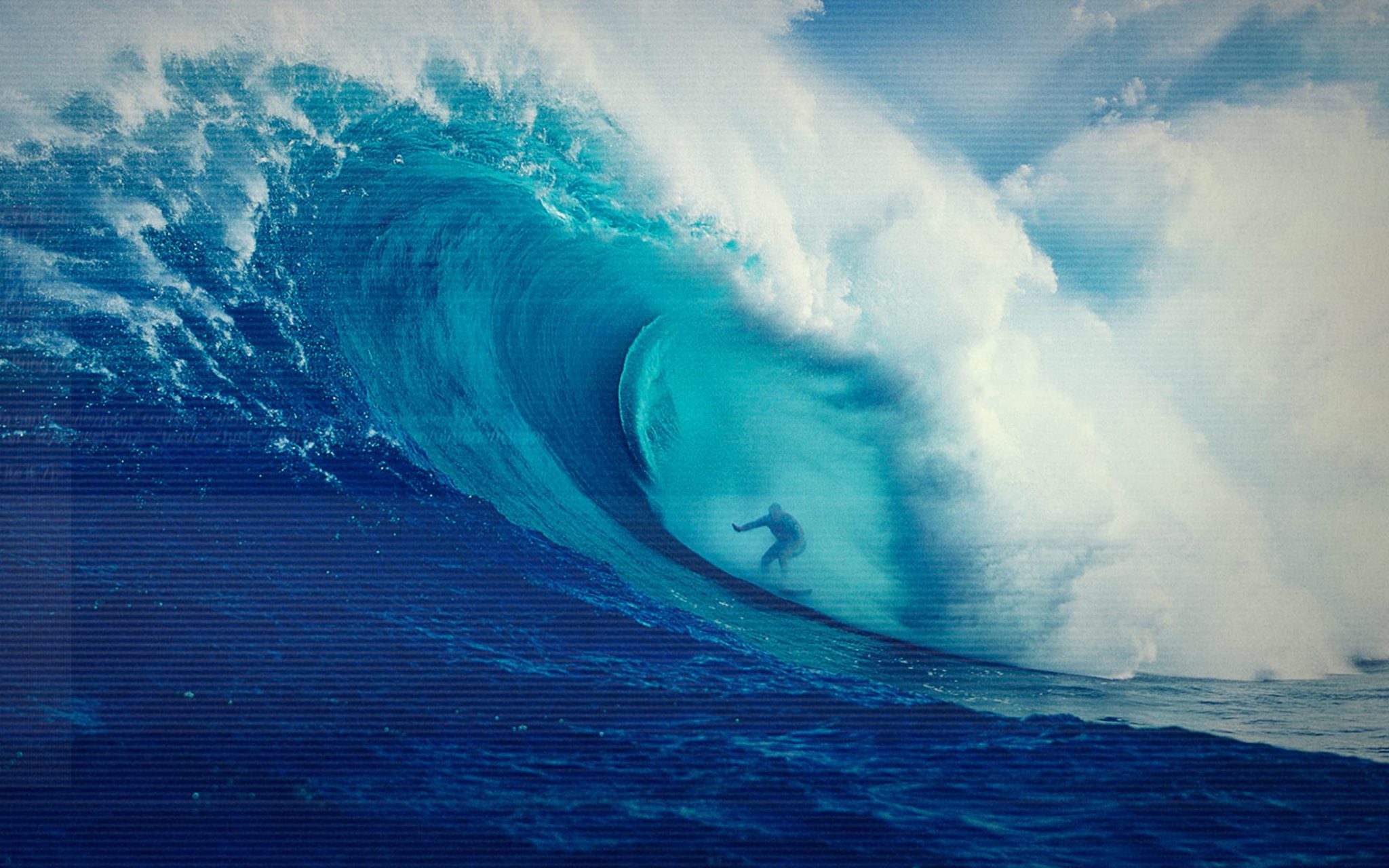 En surfare rider på en stor våg ute i det blå havet
